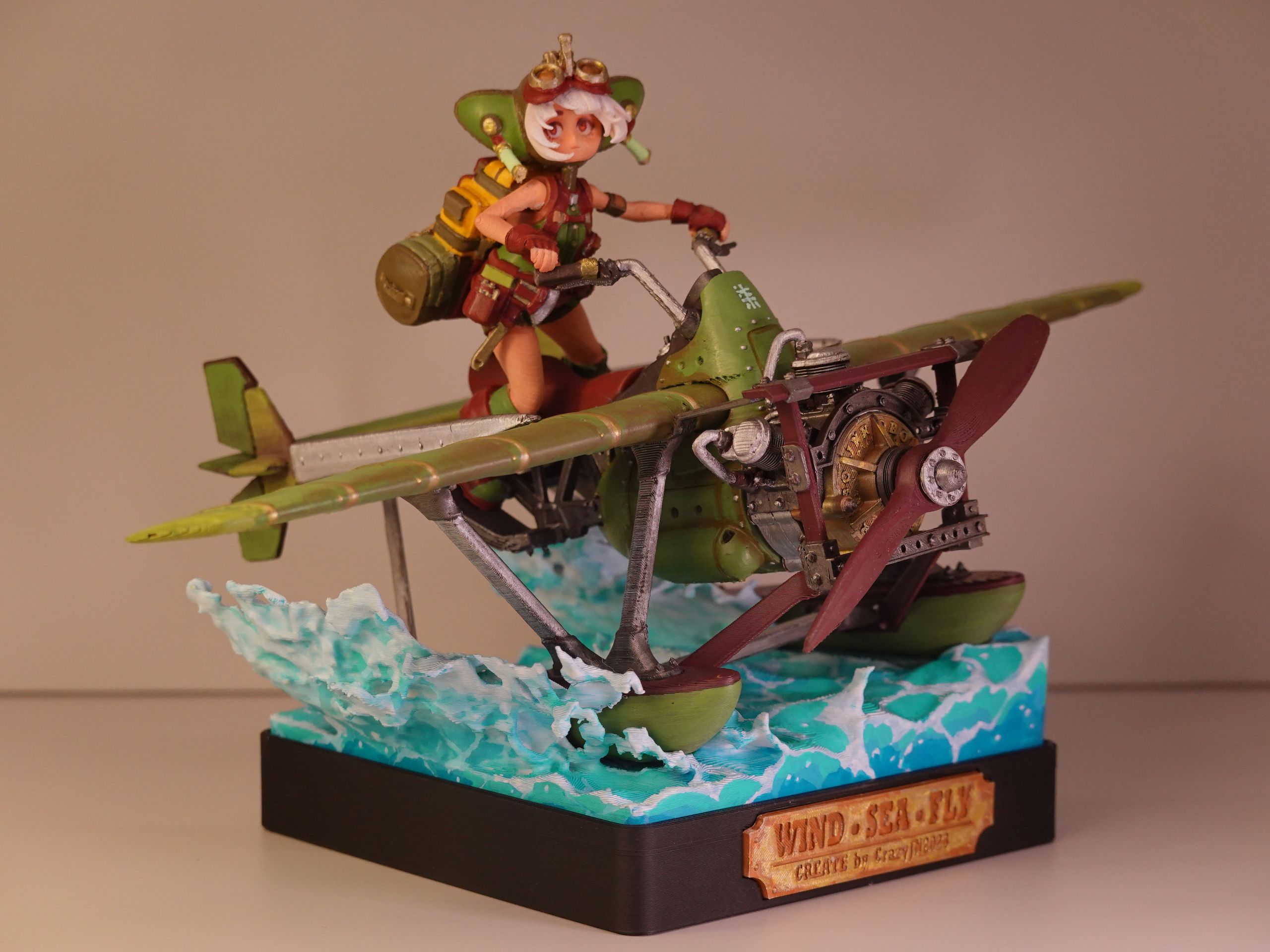 A detailed figurine of a character riding a green seaplane over water, with "Wind Sea Fly" and "Create by CrazyPing" on the base.