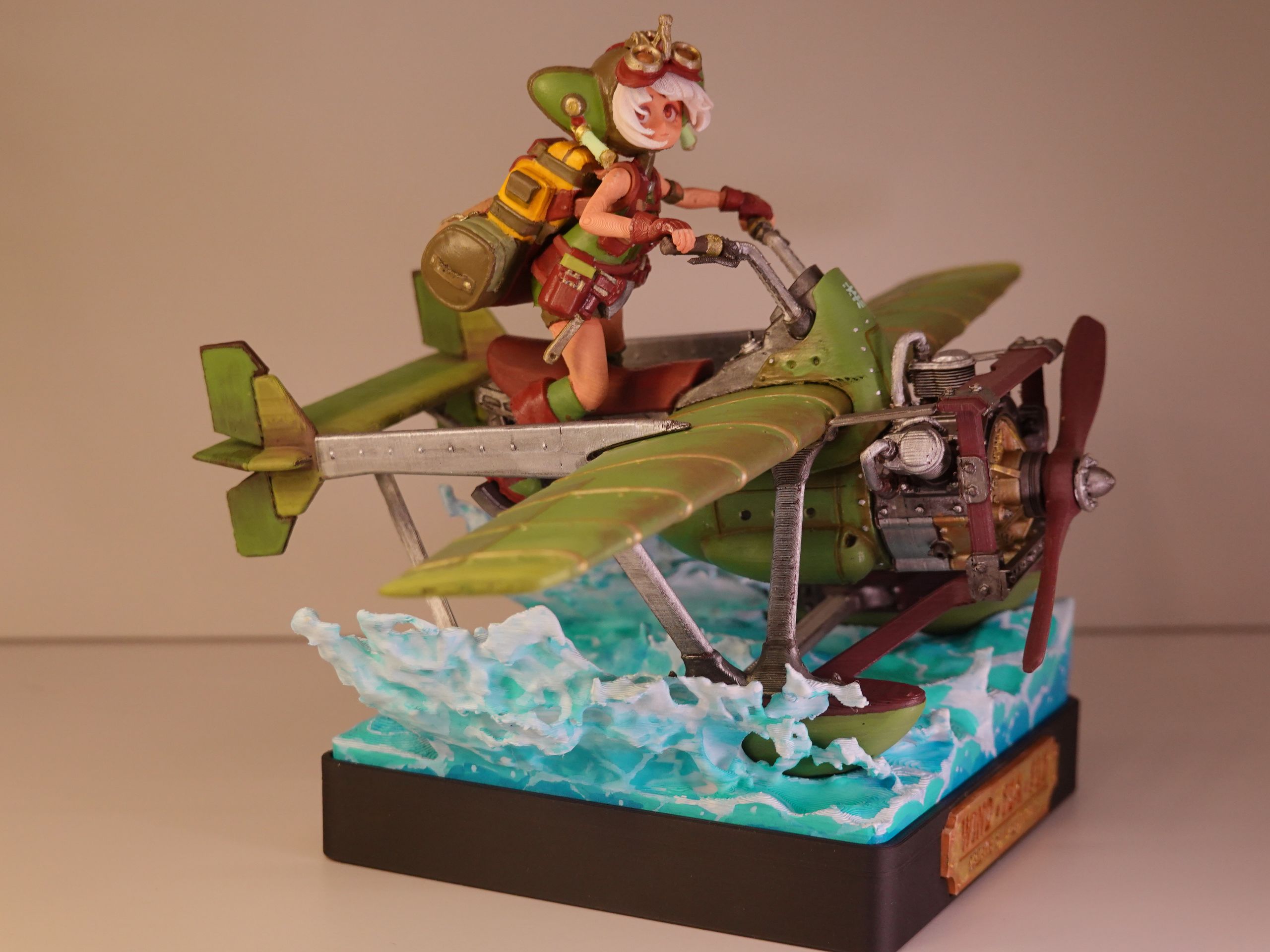 A detailed action figure of a character riding a green biplane, with water splash effect base.