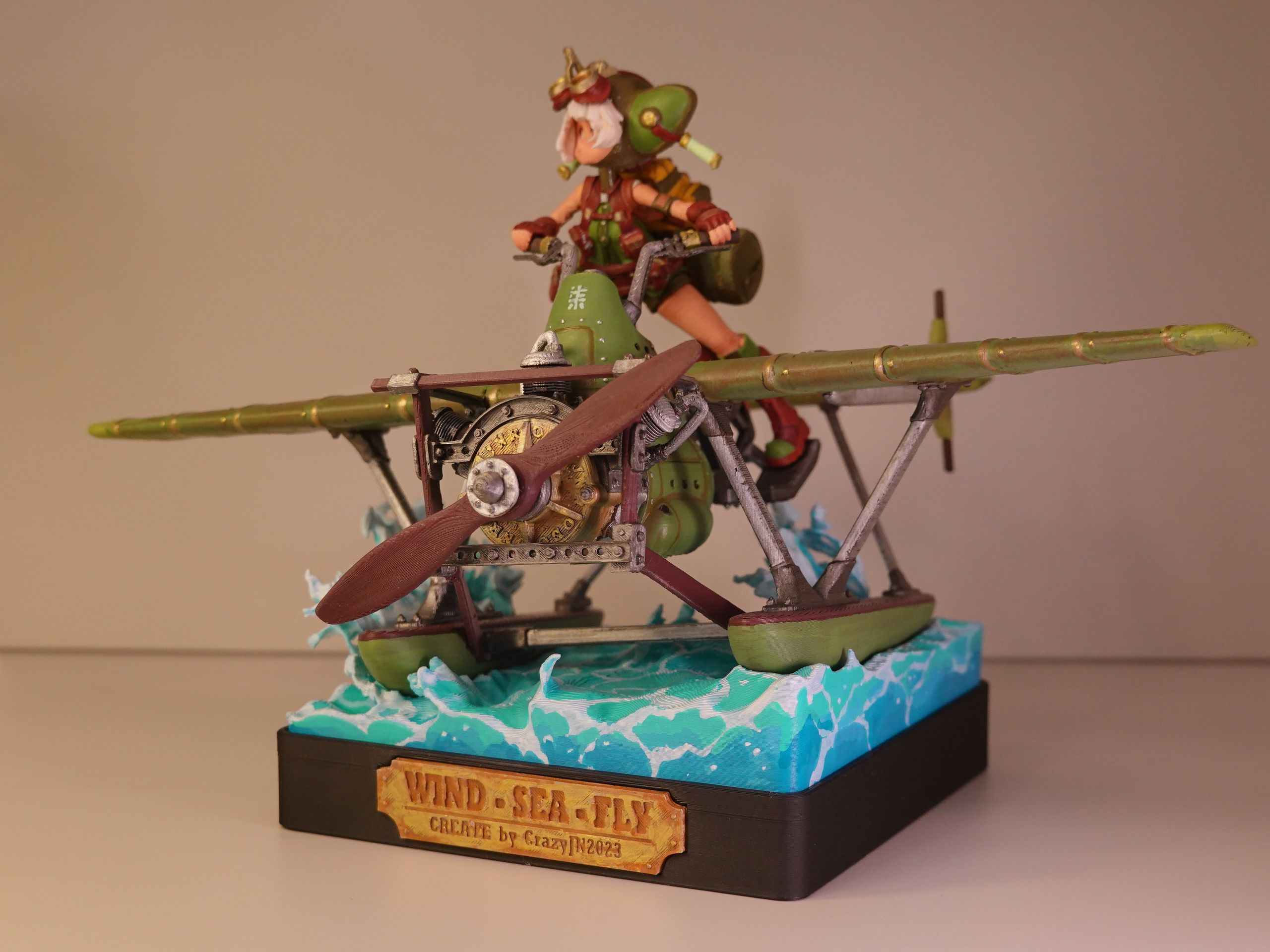 Miniature figure riding a detailed biplane, labeled "Wind-Sea-Fly" with a water base.