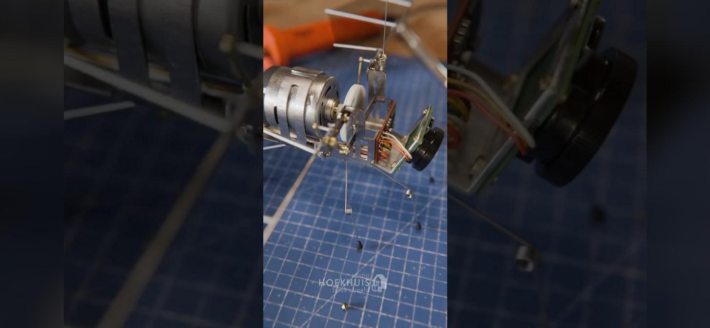 Miniature helicopter engine assembly on a blue grid mat, showcasing intricate components and assembly process.